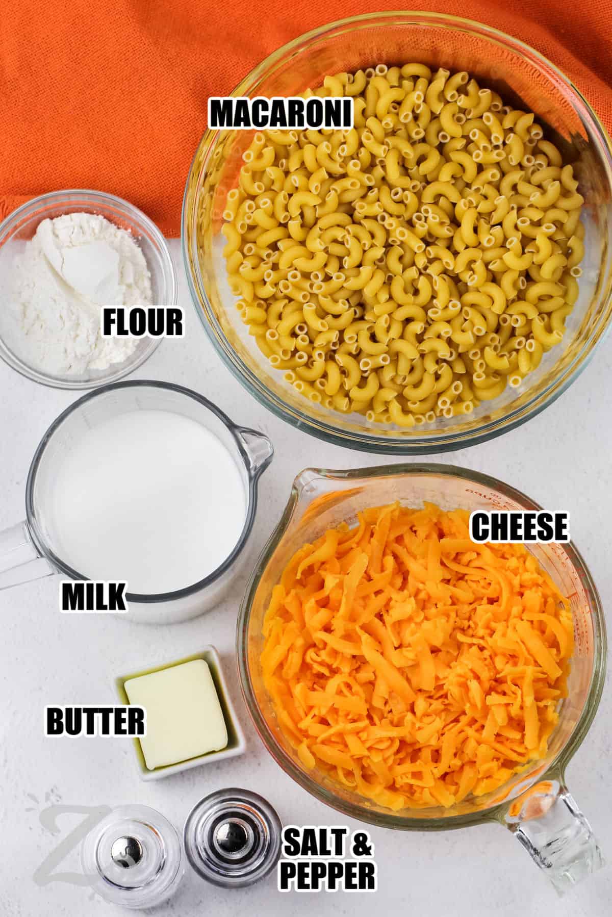 macaroni , flour , cheese , milk , butter , salt and pepper with labels to make Creamy Homemade Mac and Cheese