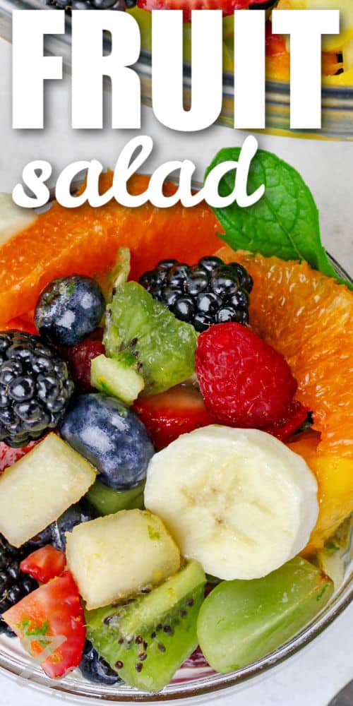 a clear bowl holds a serving of an easy recipe for fruit salad, with a title