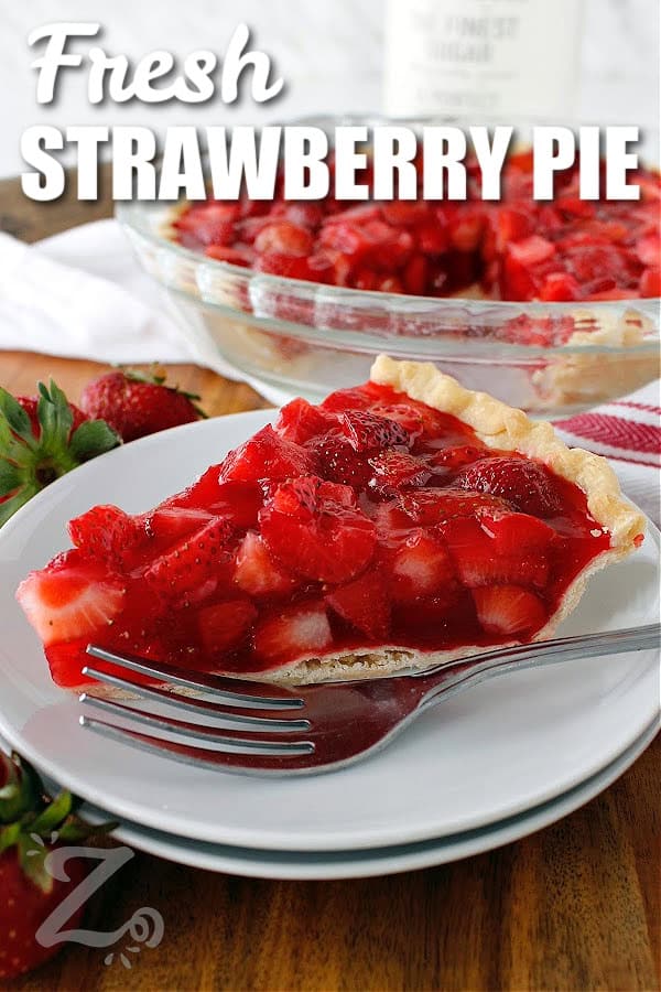 Fresh strawberry pie served on a small white plate with a fork, and the remaining pie in the background, with a title