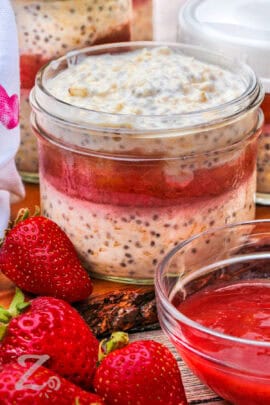 jar of Overnight Oats with strawberries around it