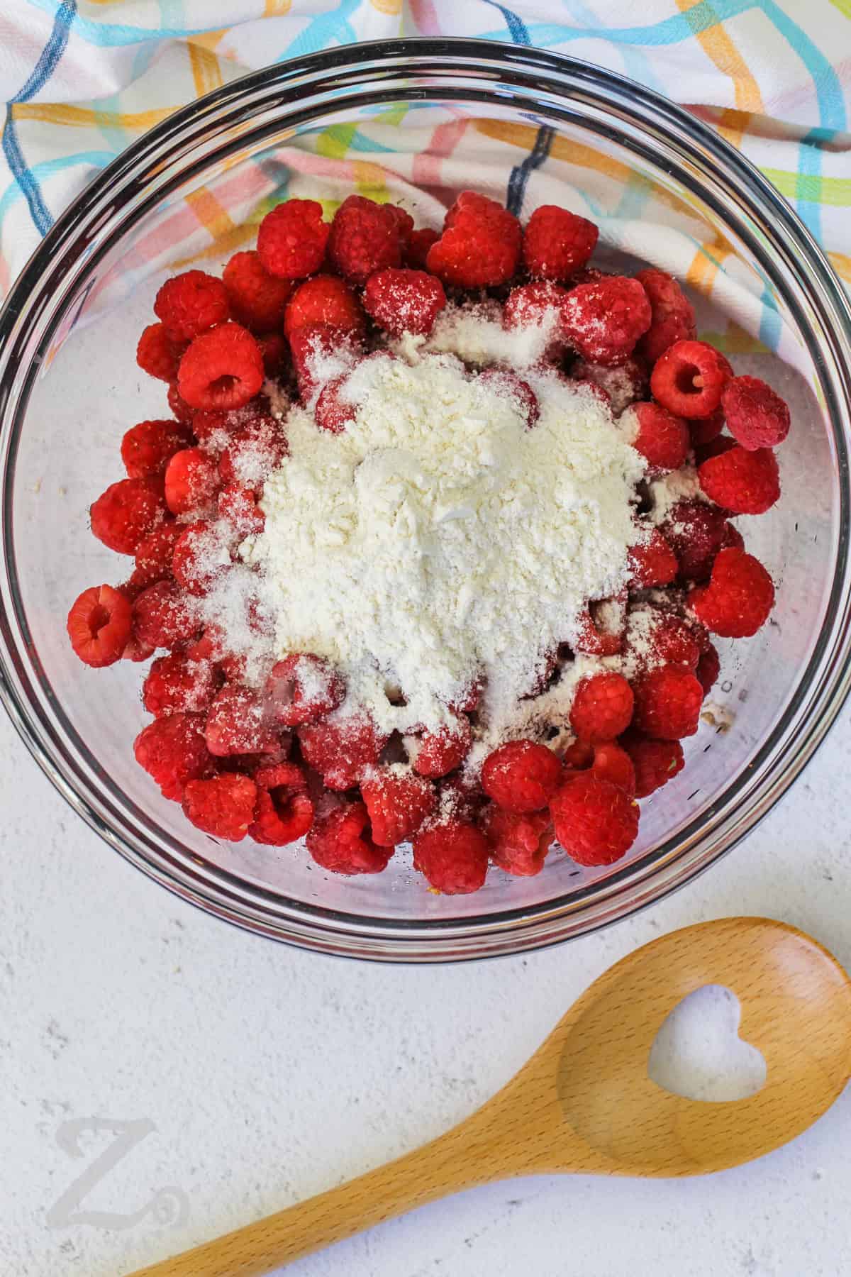 raspberries, sugar and flour in a clear bowl to make raspberry crisp