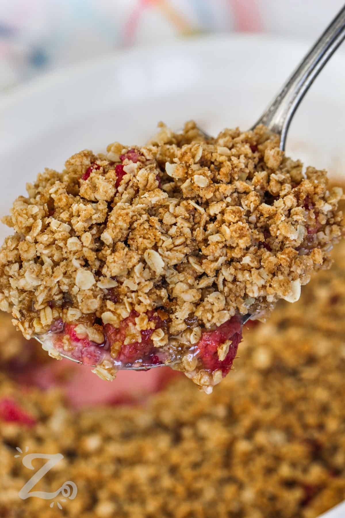 a spoon filled with raspberry crisp