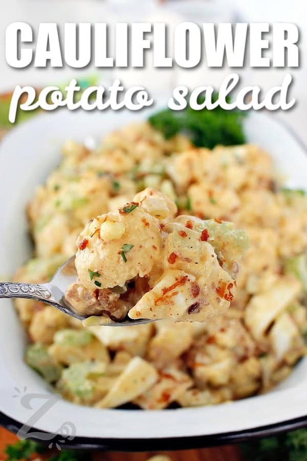 a spoonful of cauliflower potato salad with more in a white rectangular dish in the background, with a title