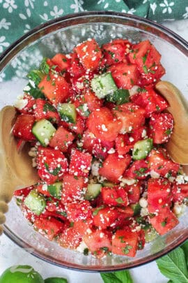 mixing Watermelon Salad in a glass bowl
