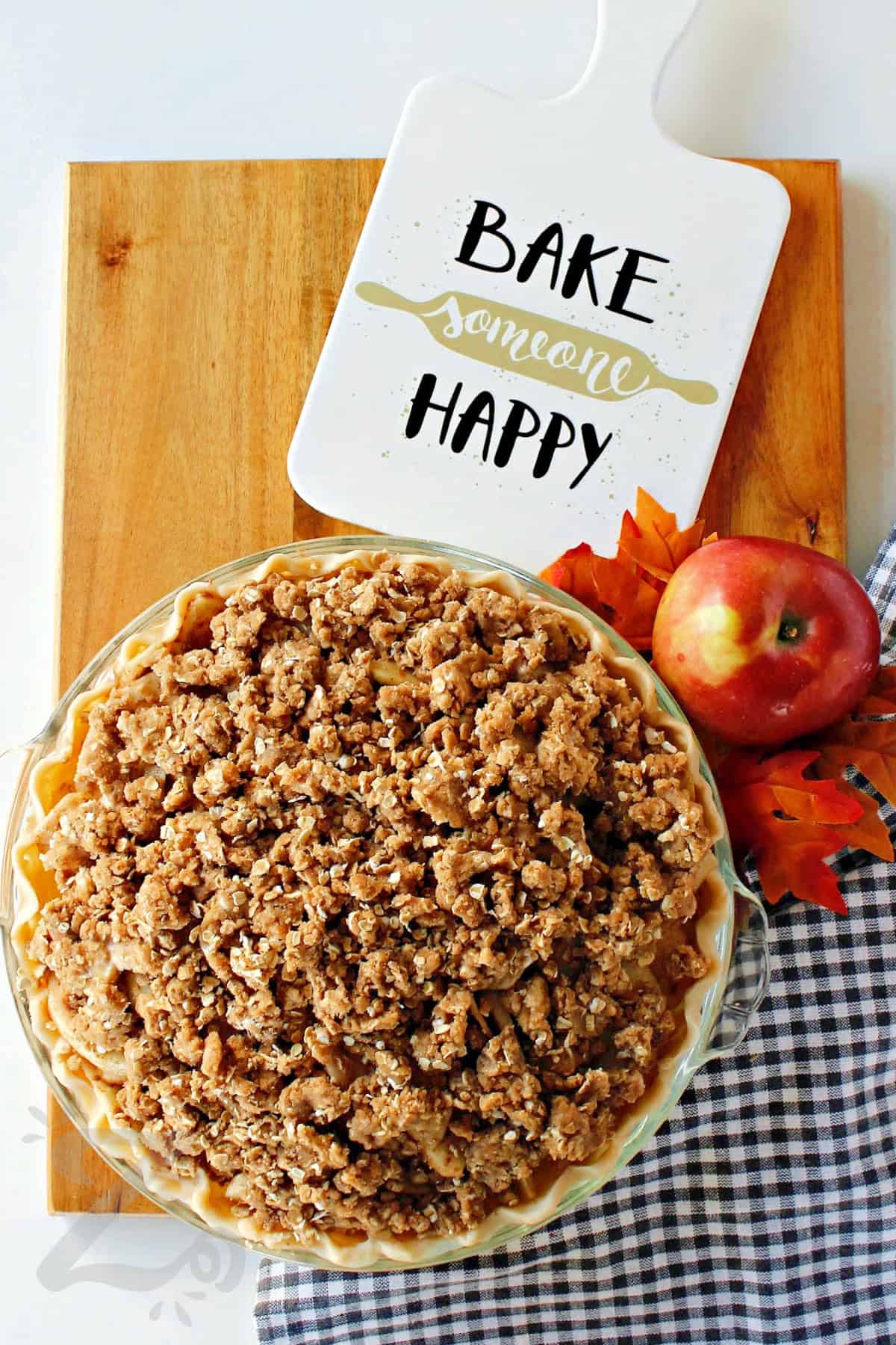 assembled apple crumb pie on a wooden board before being baked