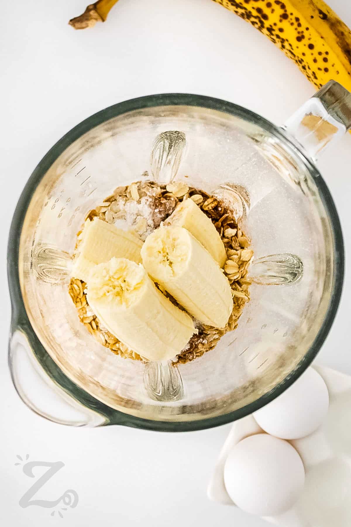 adding ingredients to blender to make Banana Oat Pancakes