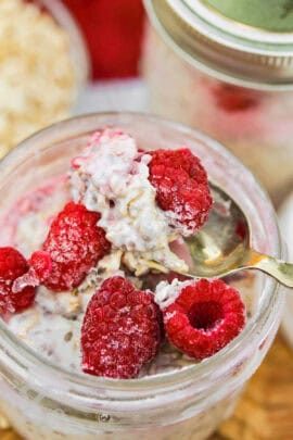 a jar of overnight oats topped with raspberries