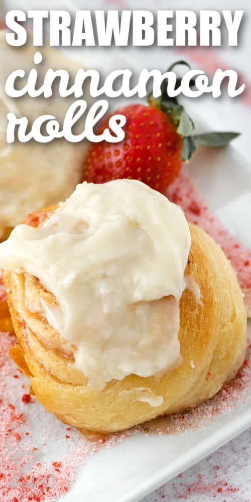 close up of Strawberry Cinnamon Rolls on a plate with a strawberry and title