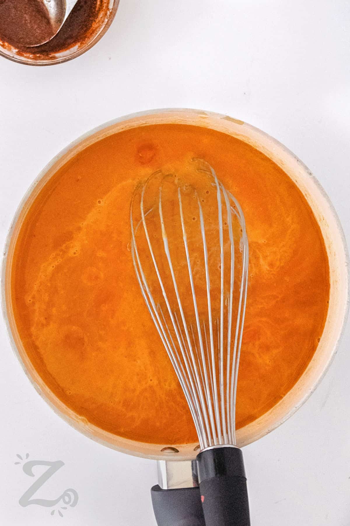 whisking ingredients together in pot to make Pumpkin Spice Syrup