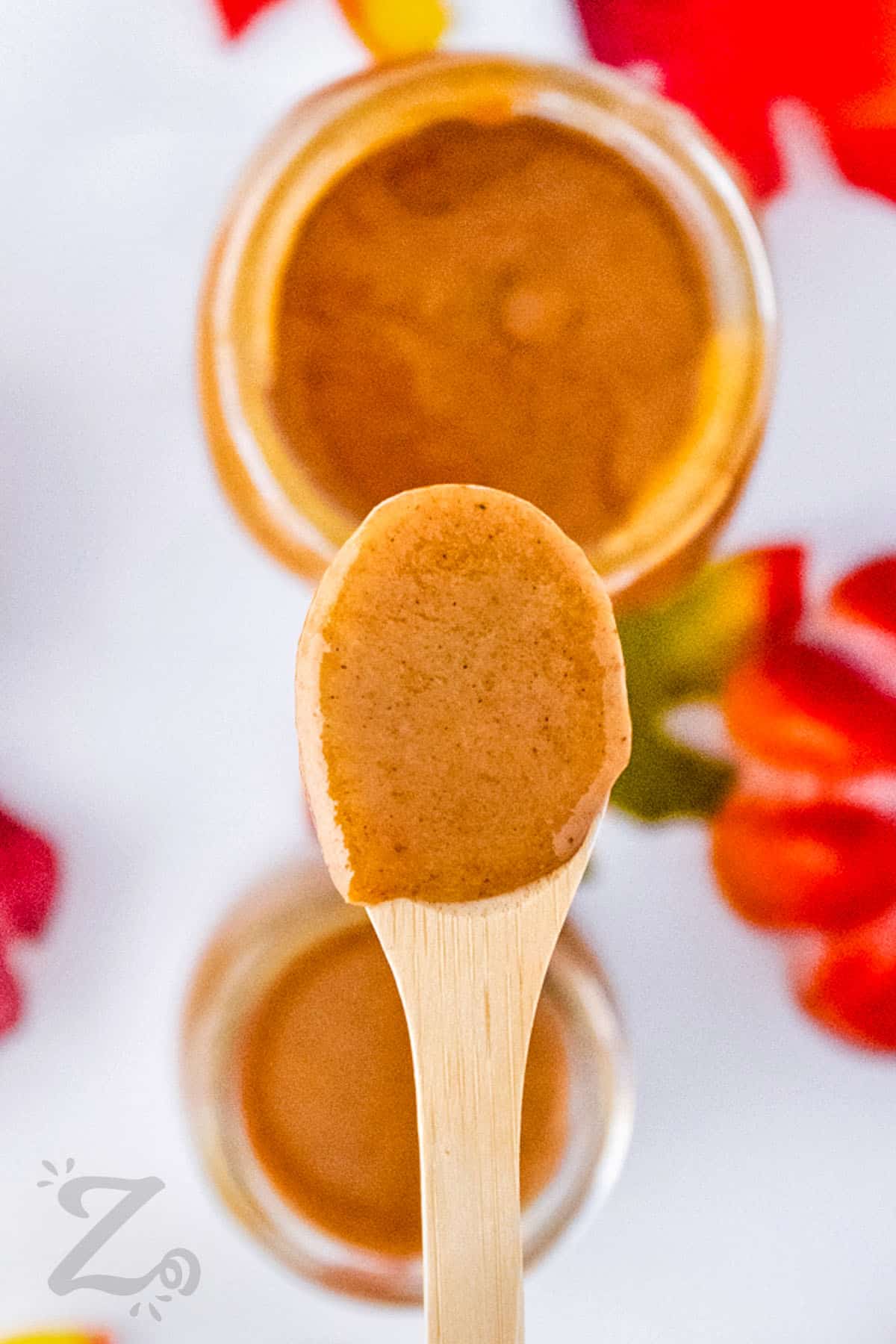 Pumpkin Spice Syrup in jars and on a wooden spoon