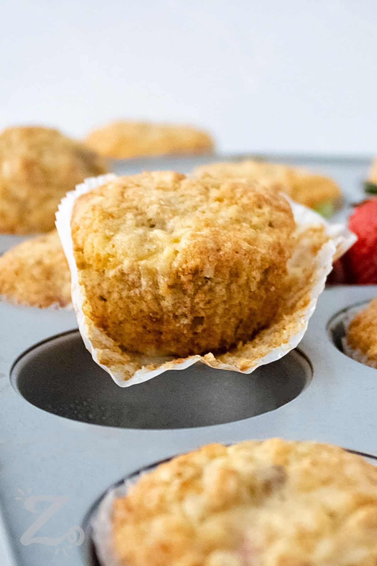 Strawberry Banana Muffins in the tin and one out of the wrapper