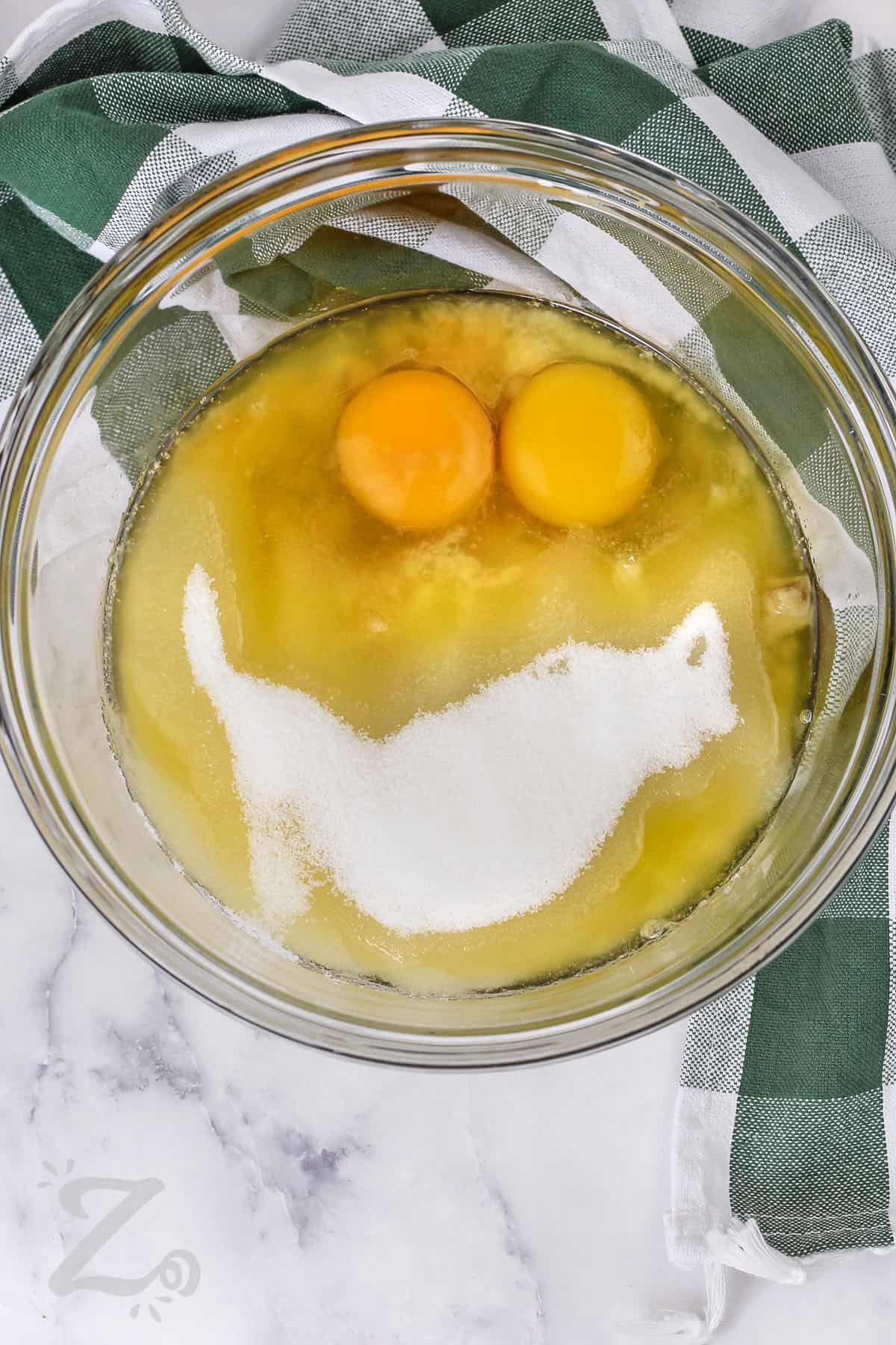 adding egg and sugar to bowl to make Chocolate Chip Banana Bread