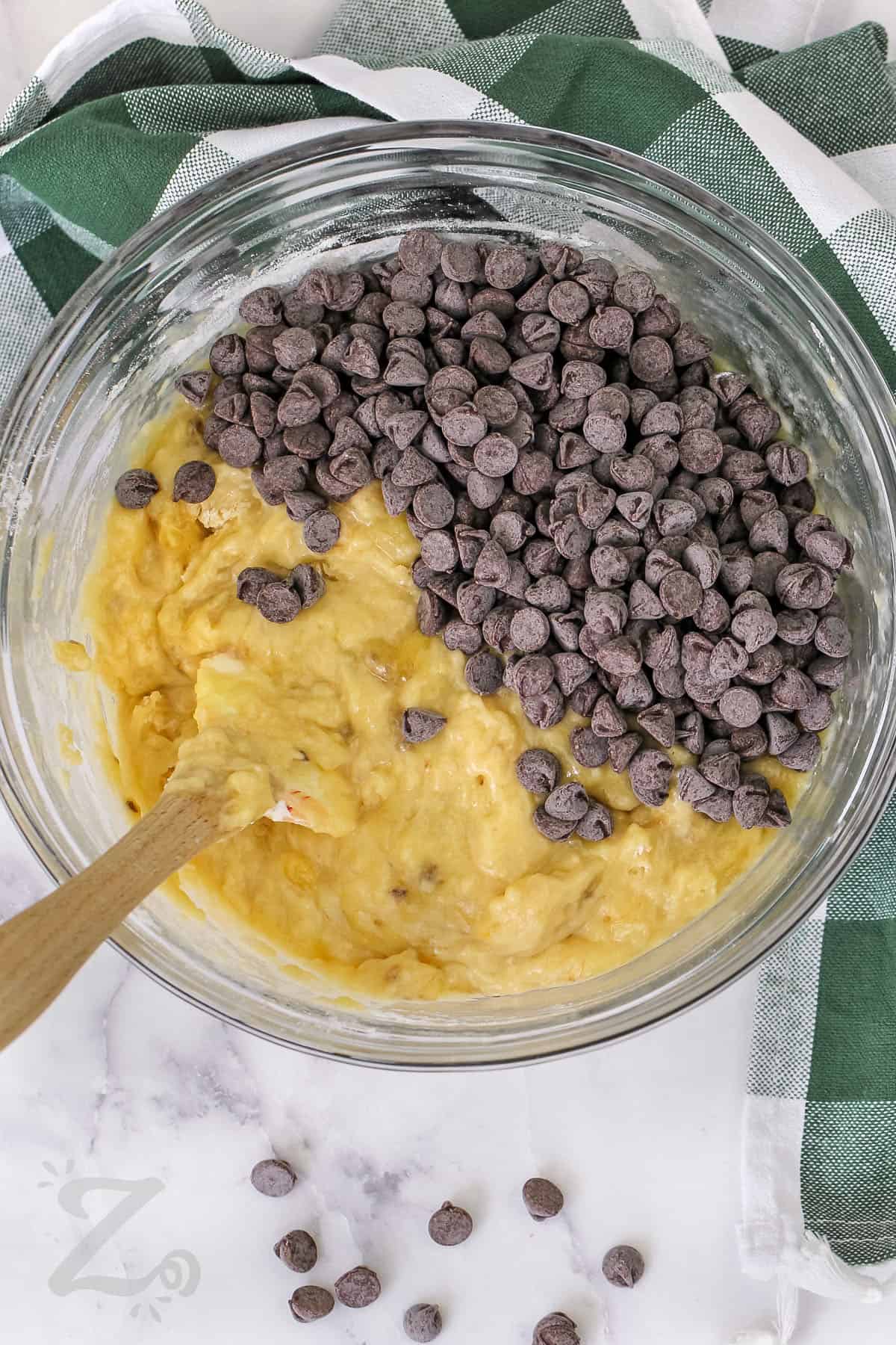 adding chocolate chips to bowl to make Chocolate Chip Banana Bread