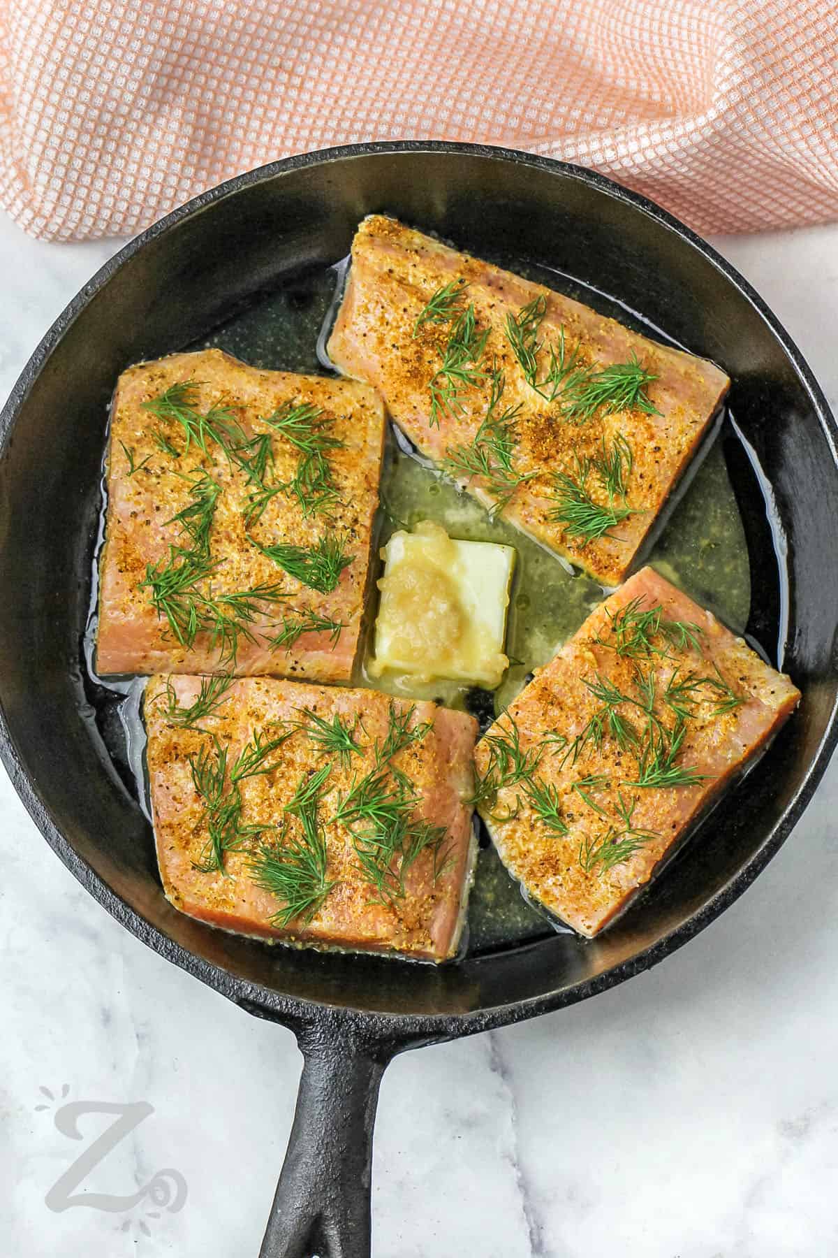 Pan Seared Salmon Filets cooking with butter and garlic