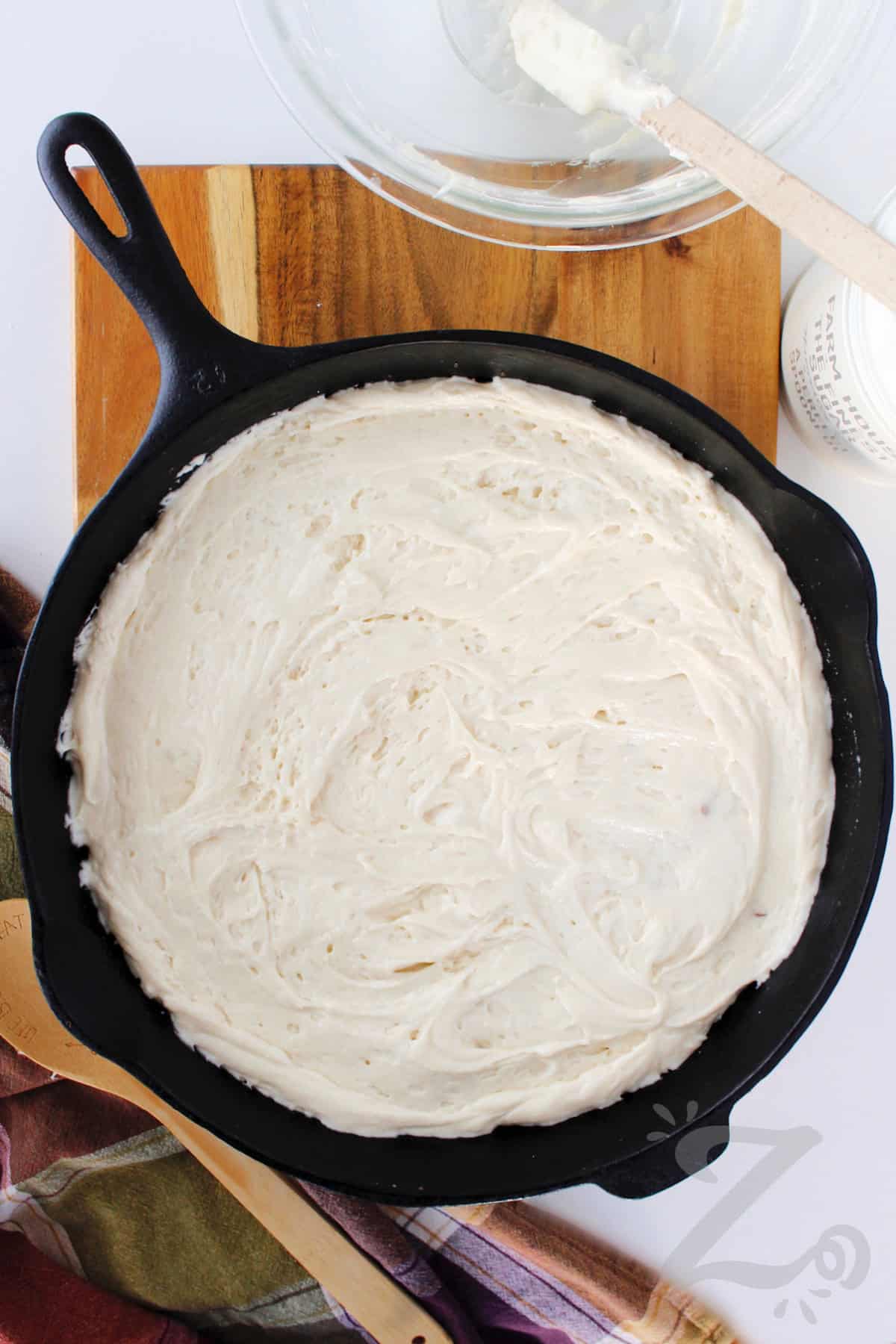 cake batter poured into a cast iron pan to make homemade pineapple upside down cake