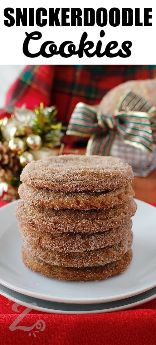 Snickerdoodle cookies stacked on a white plate with festive decor in the background, with a title