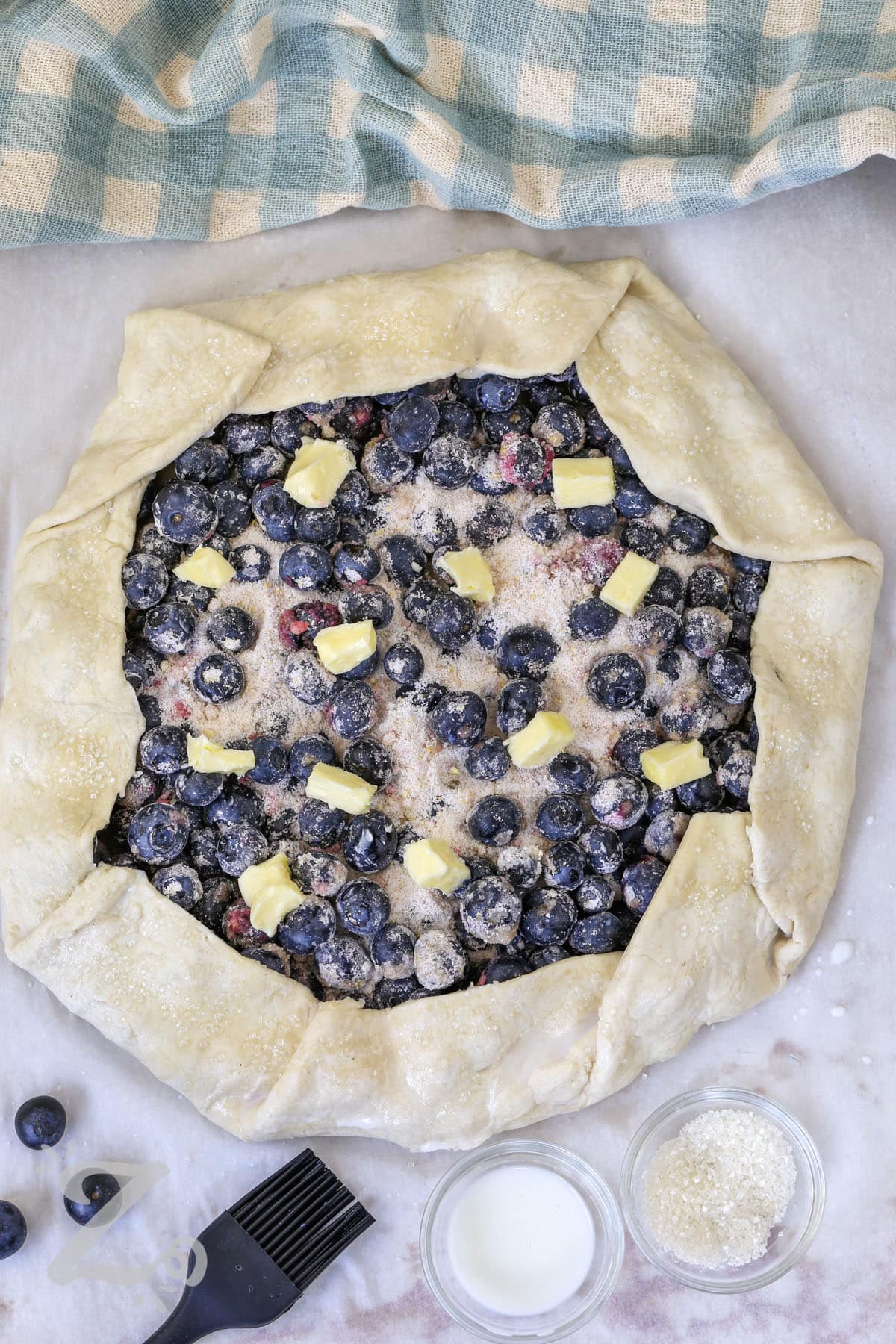 blueberry galette assembled and dotted with butter