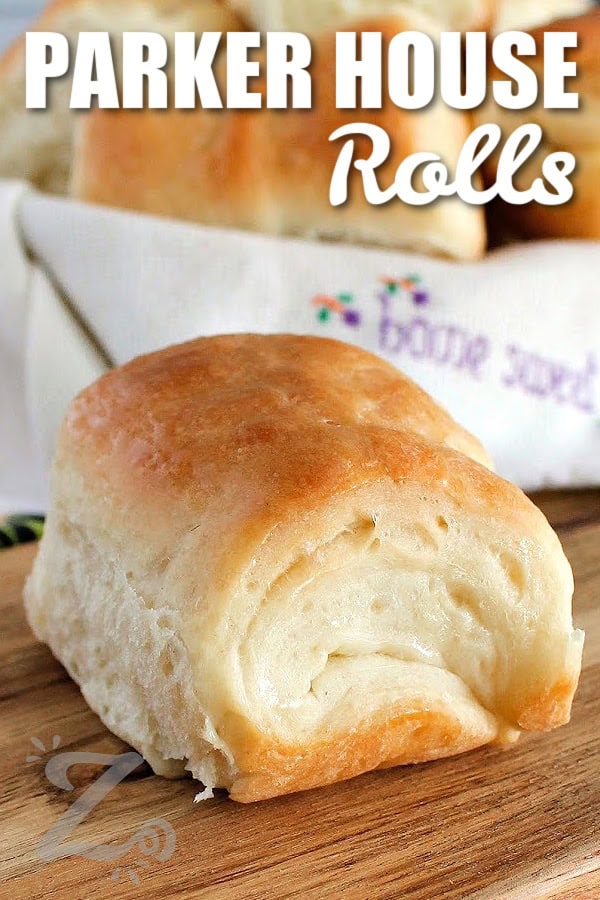 one piece of Parker House Rolls on a wooden board with a title