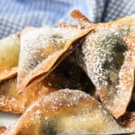 close up of Air Fryer Blueberry Cheesecake Wontons with powdered sugar on top