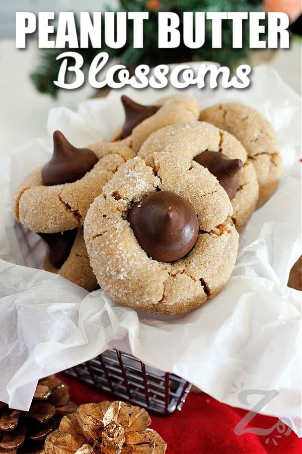 peanut butter blossoms in a parchment lined basket surrounded by festive decorations, with a title