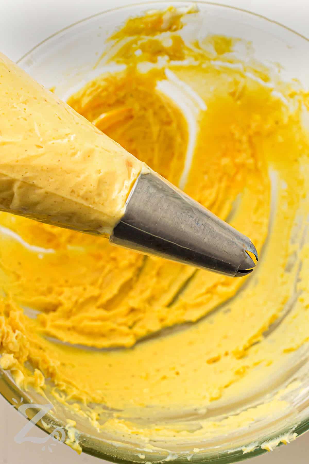 adding filling to piping tool to make Classic Deviled Eggs
