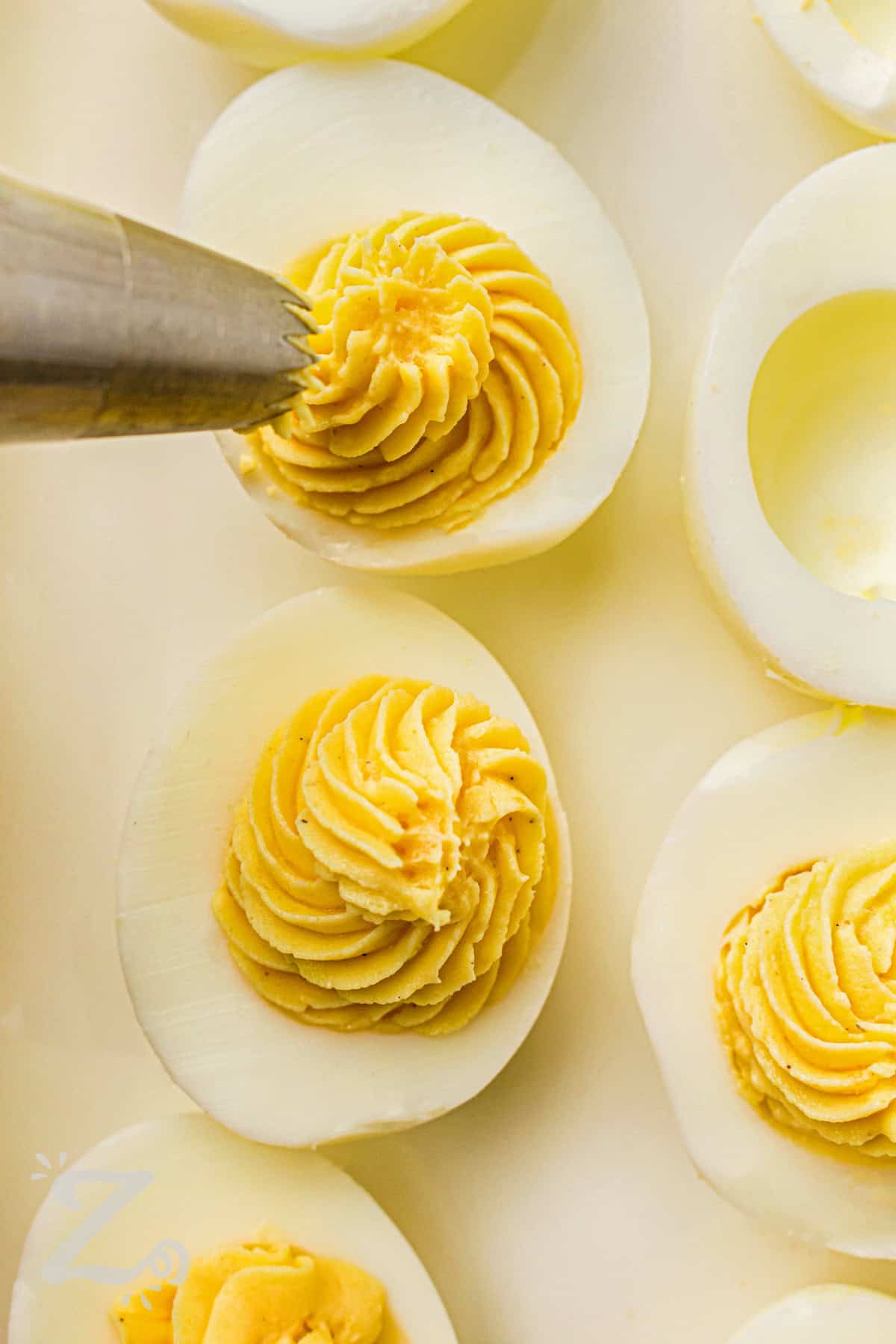 adding yolk filling to egg whites to make Classic Deviled Eggs