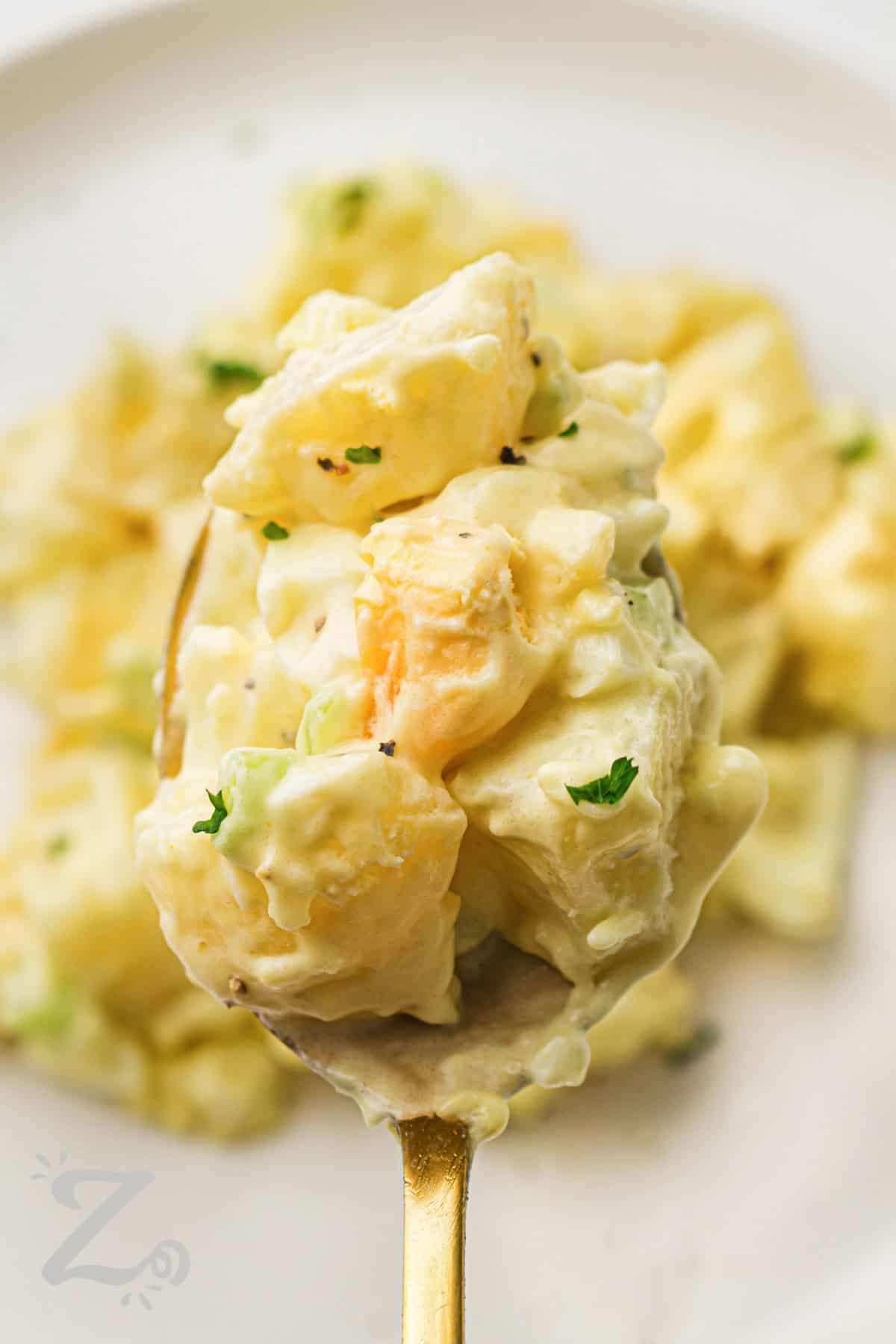 Classic potato salad recipe lovers know a creamy homemade side dish belongs at every picnic. This version combines potatoes, eggs, celery, and onion with a rich dressing made from mayo and mustard. The chilled texture and fresh flavor make it perfect for summer cookouts, potlucks, and family dinners. Pair this old-fashioned potato salad with burgers, barbecue chicken, or deli sandwiches. #ourzestylife Classic Potato Salad in a spoon
