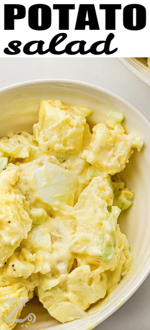 Classic potato salad recipe lovers will want this creamy side dish at every cookout. Tender potatoes, chopped eggs, crisp celery, and onion are tossed in a rich mustard mayo dressing for the perfect balance of flavor. This homemade potato salad is great for picnics, backyard barbecues, and family dinners. It tastes even better after chilling and pairs well with burgers, fried chicken, or sandwiches. #ourzestylife bowl of Classic Potato Salad with a title