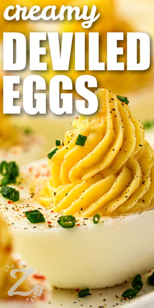close up of creamy Classic Deviled Eggs on a plate with writing