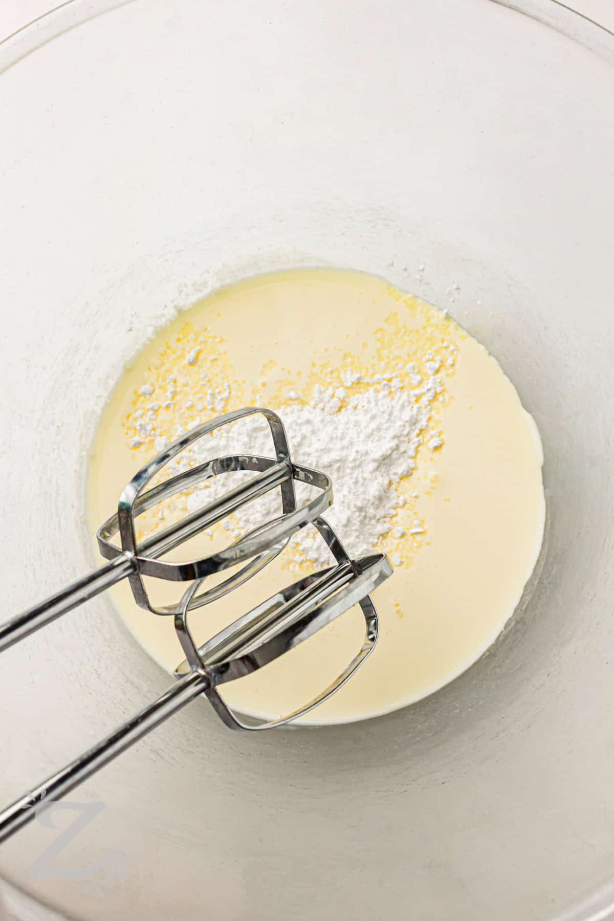 adding powdered sugar to heavy cream to make whipping cream for Strawberry Shortcake