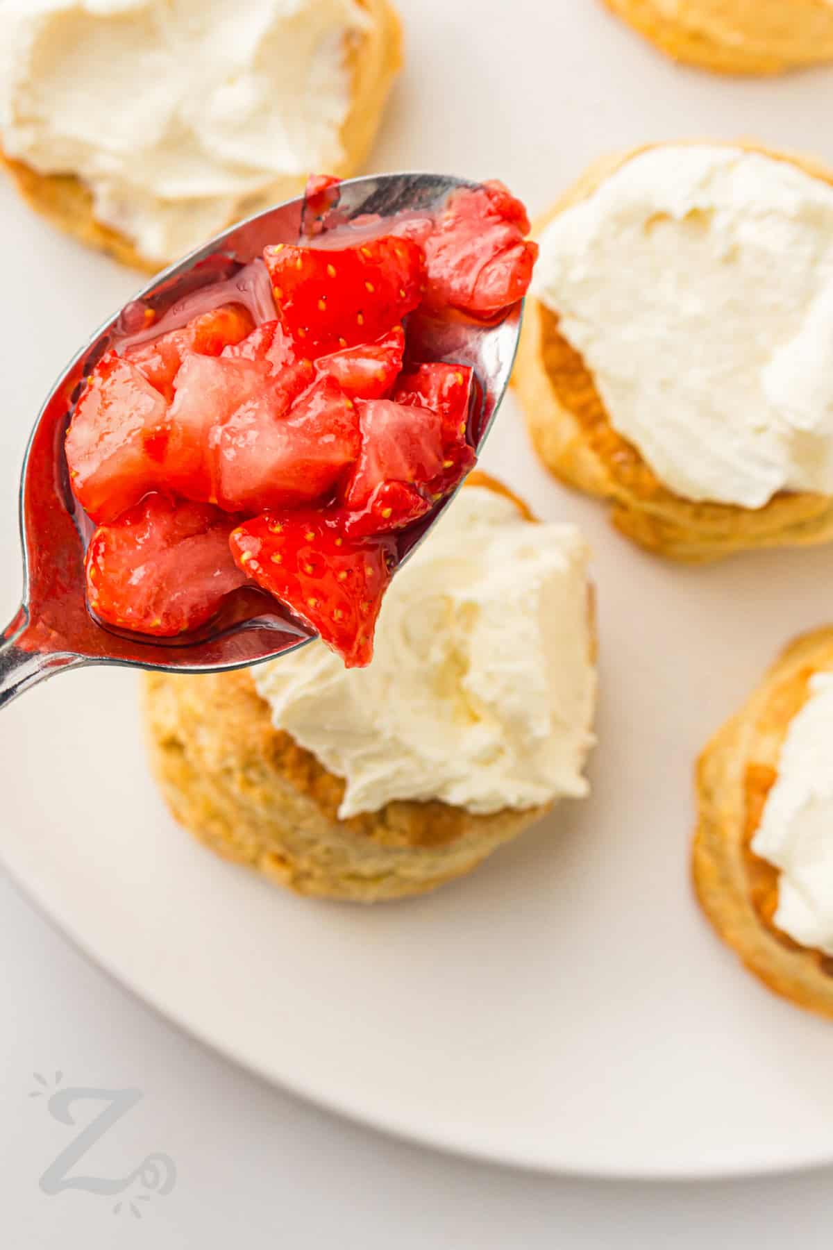 adding strawberries on top of Strawberry Shortcake