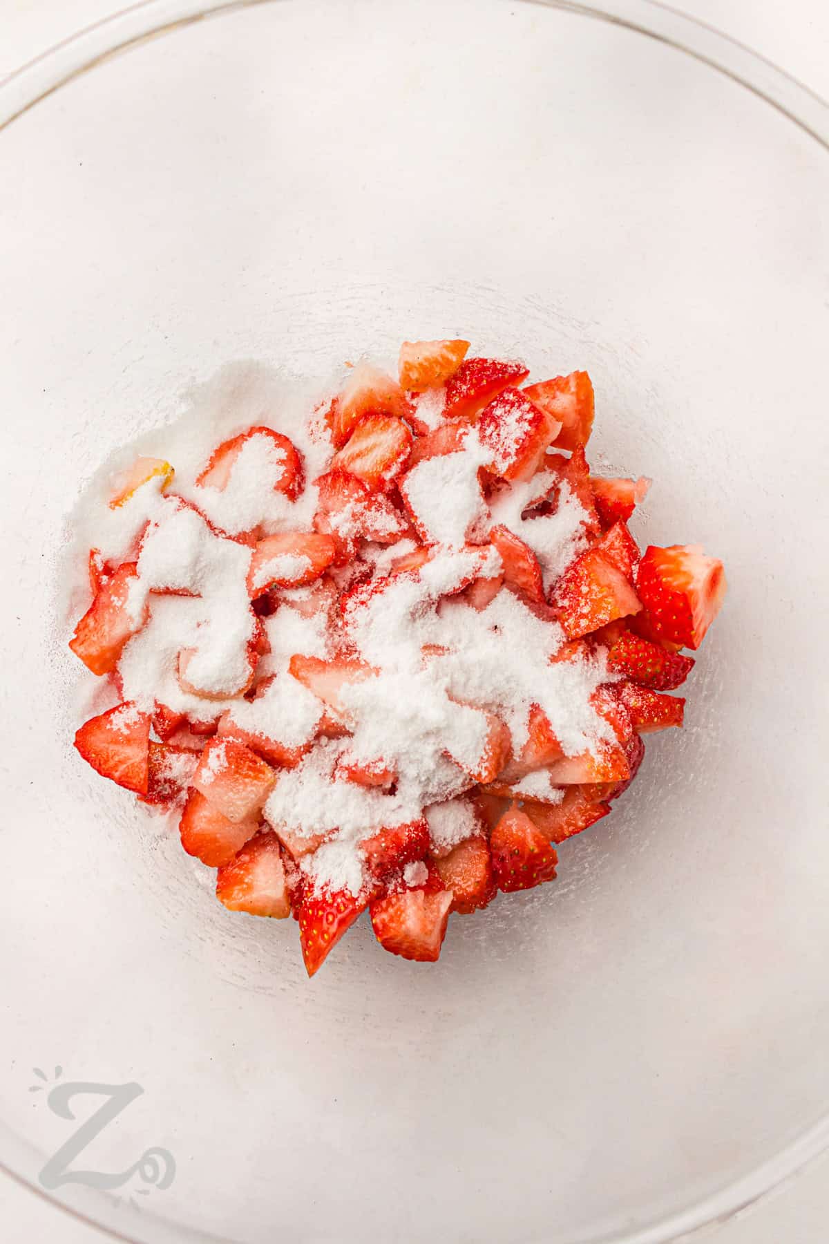 adding sugar to strawberries to make topping for Strawberry Shortcake