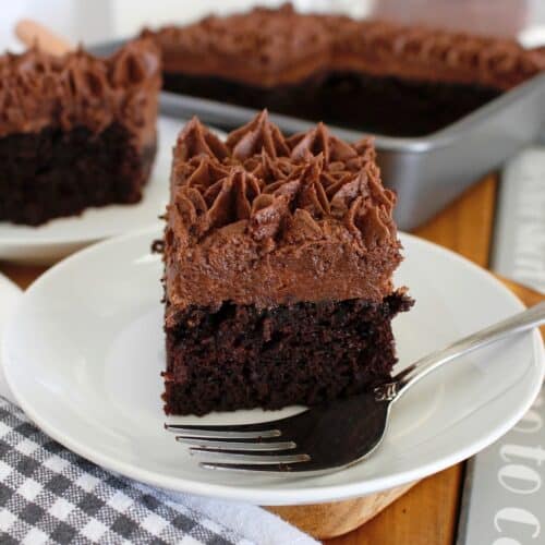 a slice of homemade chocolate cake on a white plate with a fork