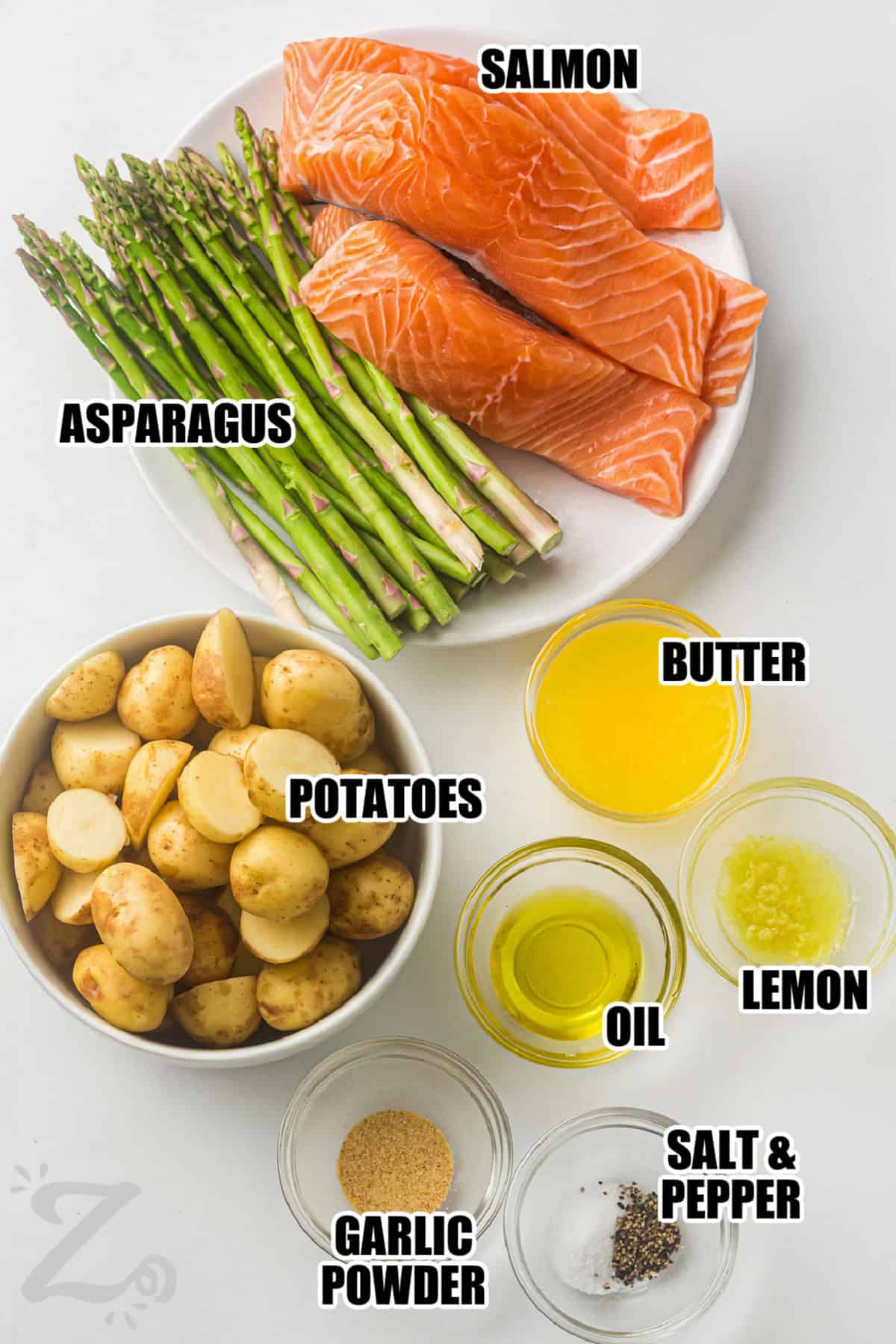 Looking for an easy dinner idea? Sheet pan salmon pairs tender roasted vegetables with perfectly cooked salmon in one simple pan. Lemon, garlic, and butter create a fresh flavor that complements every bite. This balanced meal is great for weeknights, meal planning, or serving guests without spending hours in the kitchen. Make this delicious salmon recipe today. #ourzestylife salmon , asparagus , potatoes , butter , lemon , oil , garlic powder , salt and pepper with labels to make Sheet Pan Salmon with Asparagus and Roasted Potatoes