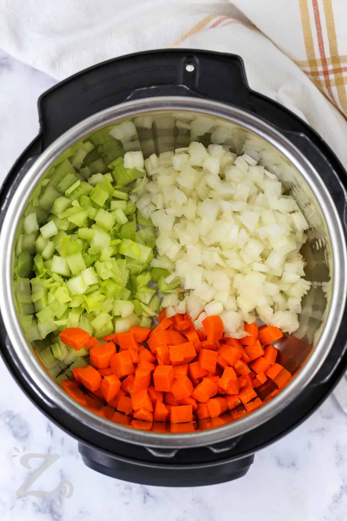 Instant Pot split pea soup is rich, hearty, and packed with smoky ham, creamy peas, and tender vegetables. This homemade soup recipe turns pantry staples into a filling family dinner that tastes comforting in every bite. The pressure cooker creates deep savory flavor while keeping this meal simple enough for busy nights. Every bowl is warm, satisfying, and perfect for cooler weather. Make this delicious recipe for supper tonight. #ourzestylife adding celery , onion and carrot to instant pot to make Instant Pot Split Pea Soup with Ham
