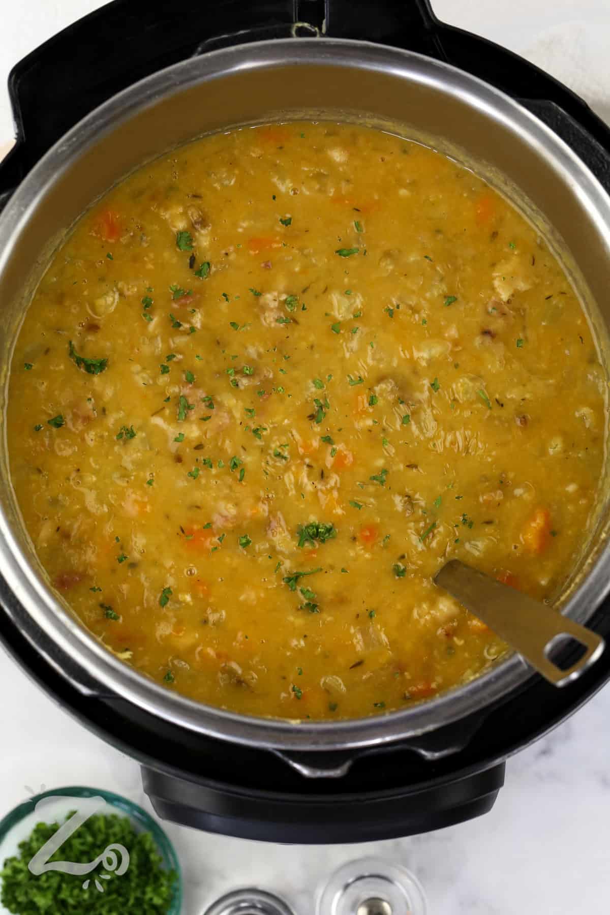 When you are looking for an easy comfort food dinner, Instant Pot split pea soup is the answer. It is thick, hearty, and loaded with smoky ham and creamy split peas. Carrots, celery, onion, and herbs give this homemade soup recipe a rich, savory flavor that tastes even better the next day. This pressure cooker meal is filling, budget-friendly, and perfect for soup season. Every bowl is warm and satisfying for the whole family. Make this delicious soup for supper tonight. #ourzestylife Instant Pot Split Pea Soup with Ham in the pot