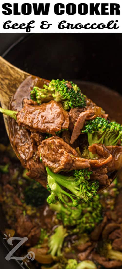 Slow cooker beef and broccoli turns everyday ingredients into a flavorful Crockpot dinner. It is packed with garlic, soy sauce, onion, and tender beef that cooks low and slow. The broccoli adds a fresh bite that pairs perfectly with the rich sauce. This dish is great for busy weeknights or relaxed weekends. Make it for dinner and enjoy a homemade meal with ease. #ourzestylife taking Slow Cooker Beef and Broccoli out of the cooker with a wooden spoon with a title