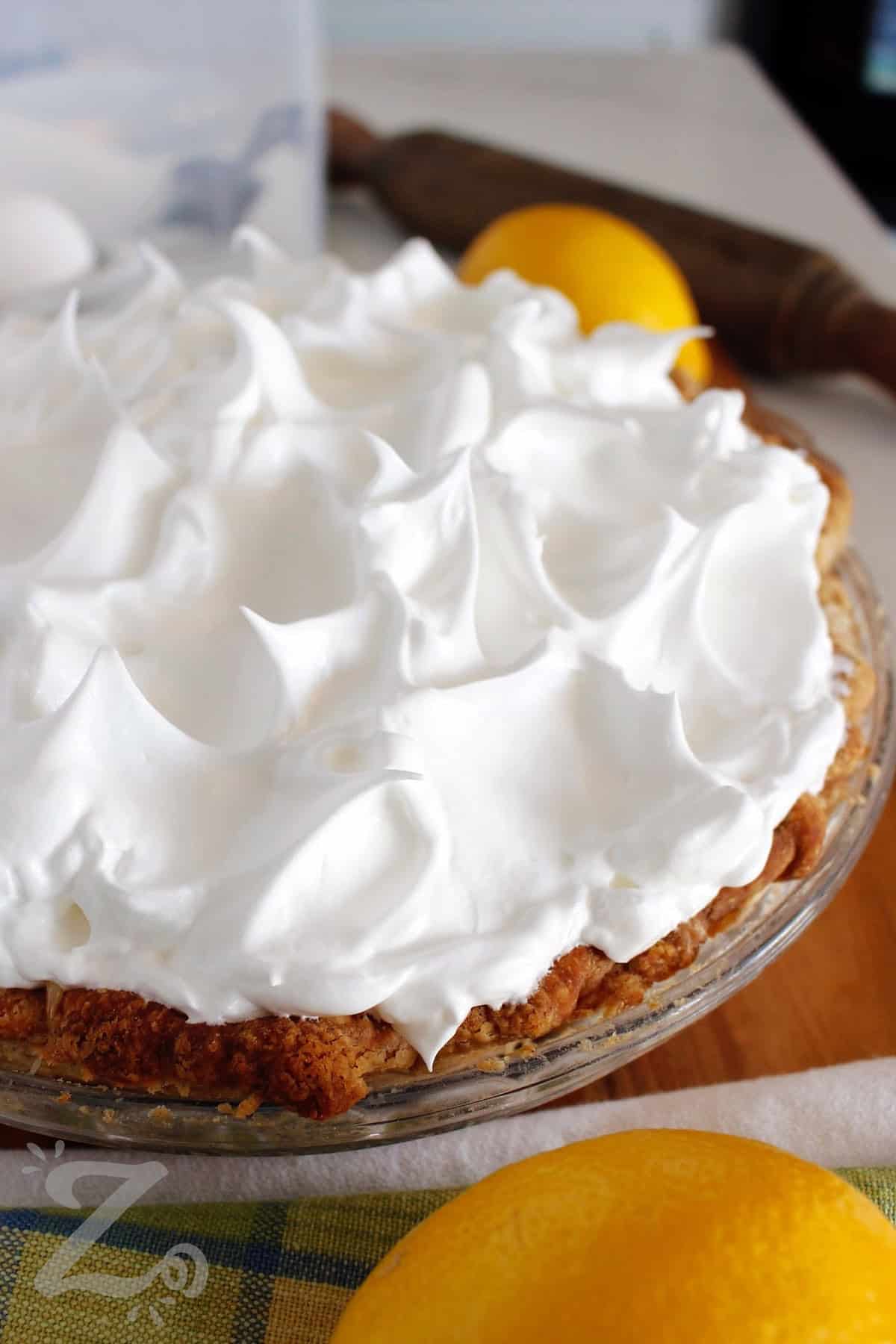 a whole lemon meringue pie with a lemon on the side, before being baked