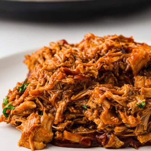 close up of saucy Slow Cooker BBQ Pulled Pork on a plate