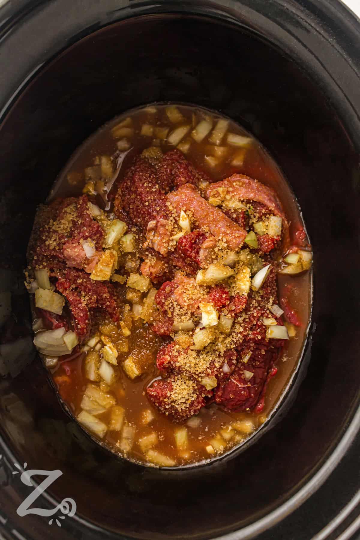 Slow cooker beef and broccoli is a family-friendly dinner that brings bold flavor with very little effort. The beef cooks slowly until it is tender and coated in a sweet and savory sauce. Broccoli is added near the end to keep it bright and fresh. This recipe works well for meal prep and leftovers for the next day. Make it for your next dinner and enjoy a simple, comforting meal. #ourzestylife adding broth with beef to make Slow Cooker Beef and Broccoli