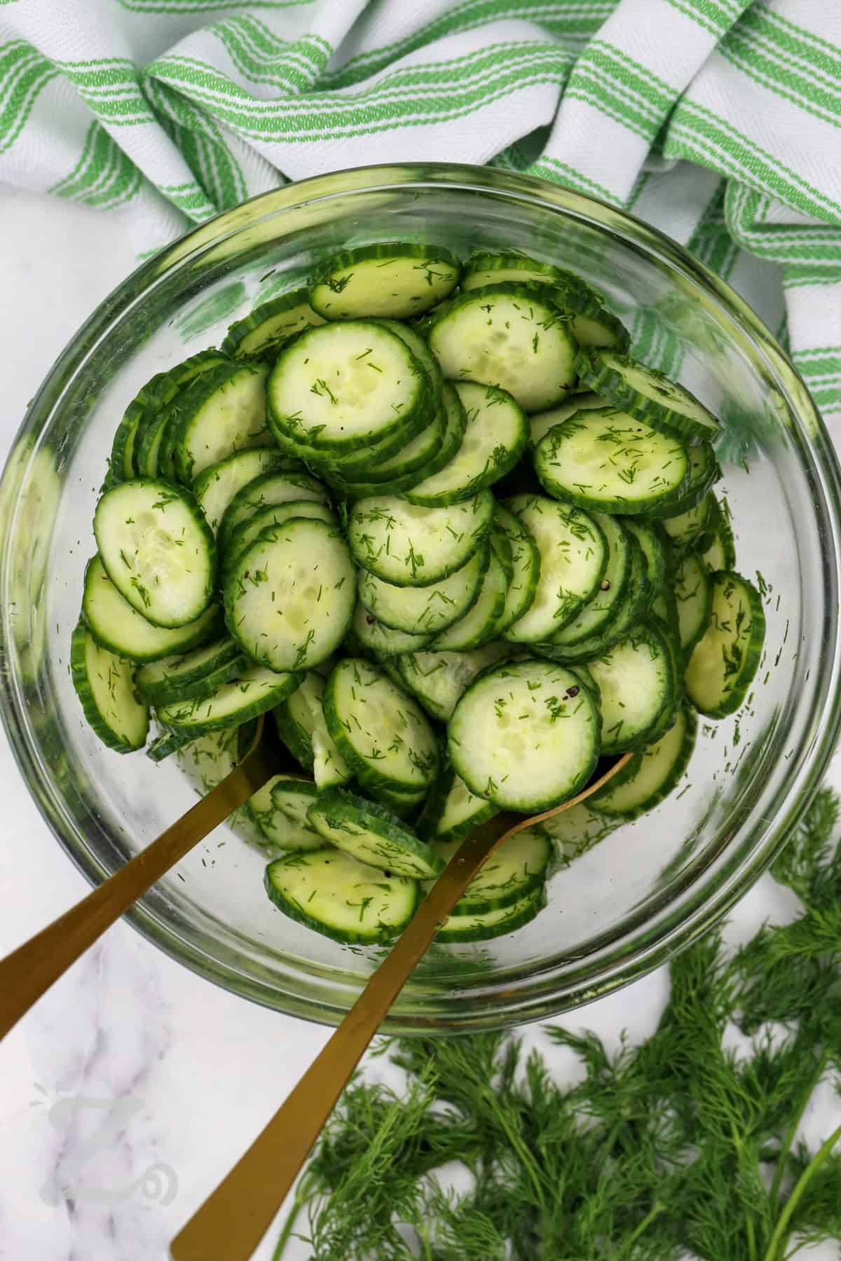 You will love this easy cucumber salad for its bright flavor and crisp texture. A light dressing with white wine vinegar, fresh dill, and black pepper keeps every bite refreshing and delicious. This classic cucumber salad is a wonderful side dish for cookouts, family dinners, and holiday meals. Try it with your favorite main course. #ourzestylife Easy Cucumber Salad mixed in a bowl