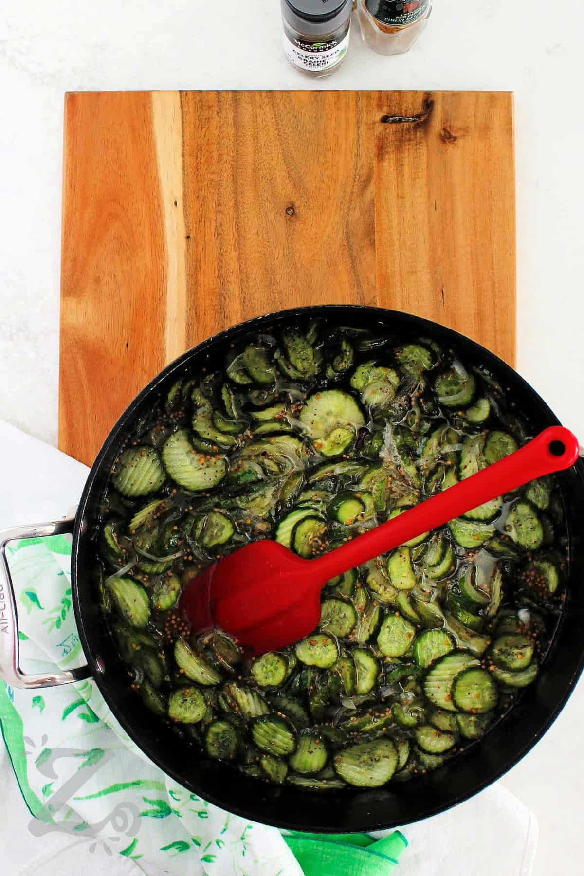 Sweet and tangy sliced pickles are easy to make with this bread and butter pickles recipe! Fresh cucumbers, onions, sugar, and spices are transformed into crisp and crunchy pickles perfect for beginners or experienced cooks alike. They make a delicious addition to a charcuterie board or just on a bbq burger. Use the refrigerator method, or the canning method. Your pick! #ourzestylife process to make bread and butter pickles recipe where cucumbers and onions have been cooked in the brine