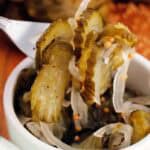 close up of bread and butter pickles recipe on a fork in a small white bowl