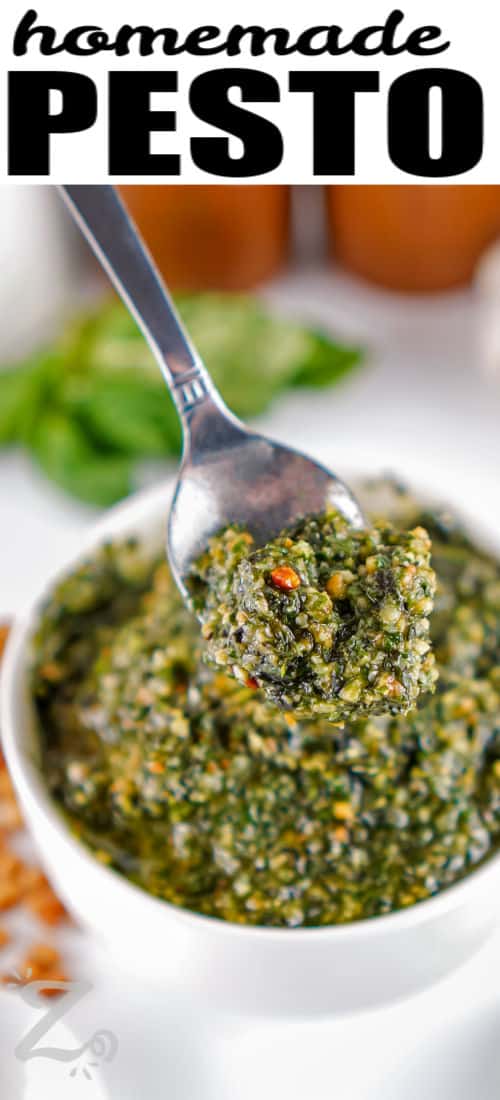 taking a spoonful of Homemade Pesto out of the dish with a title