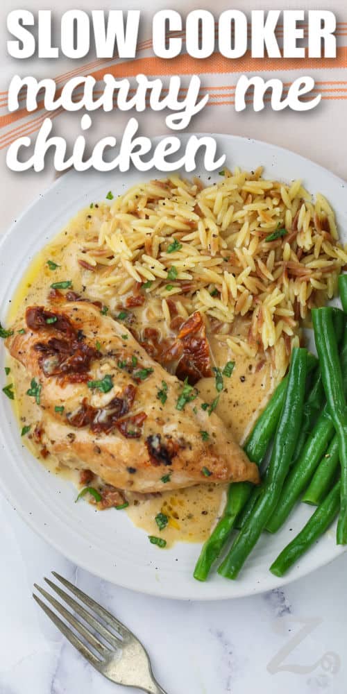 Slow Cooker Marry Me Chicken on a plate with rice and beans with a title