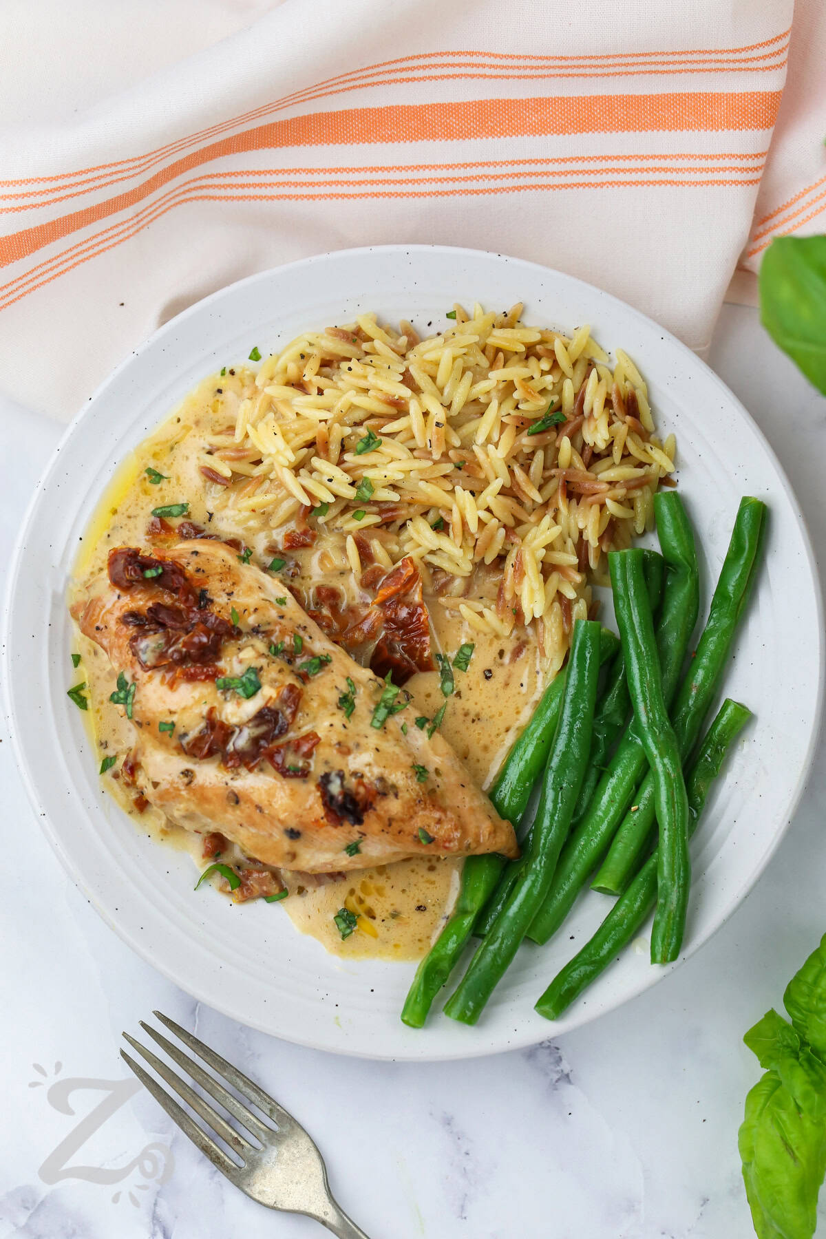 top view of Slow Cooker Marry Me Chicken on a plate on rice with green beans
