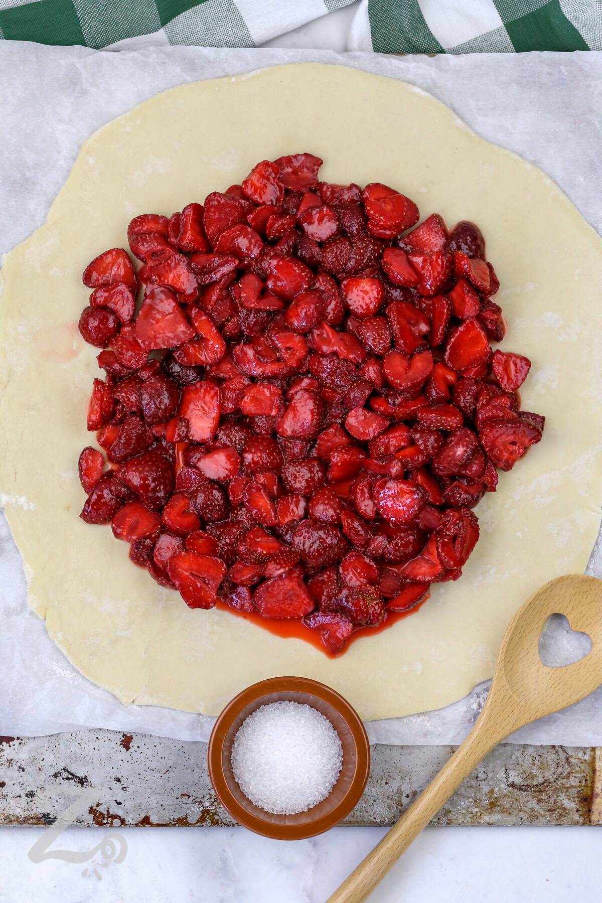 adding strawberry mixture to dough to make Strawberry Galette