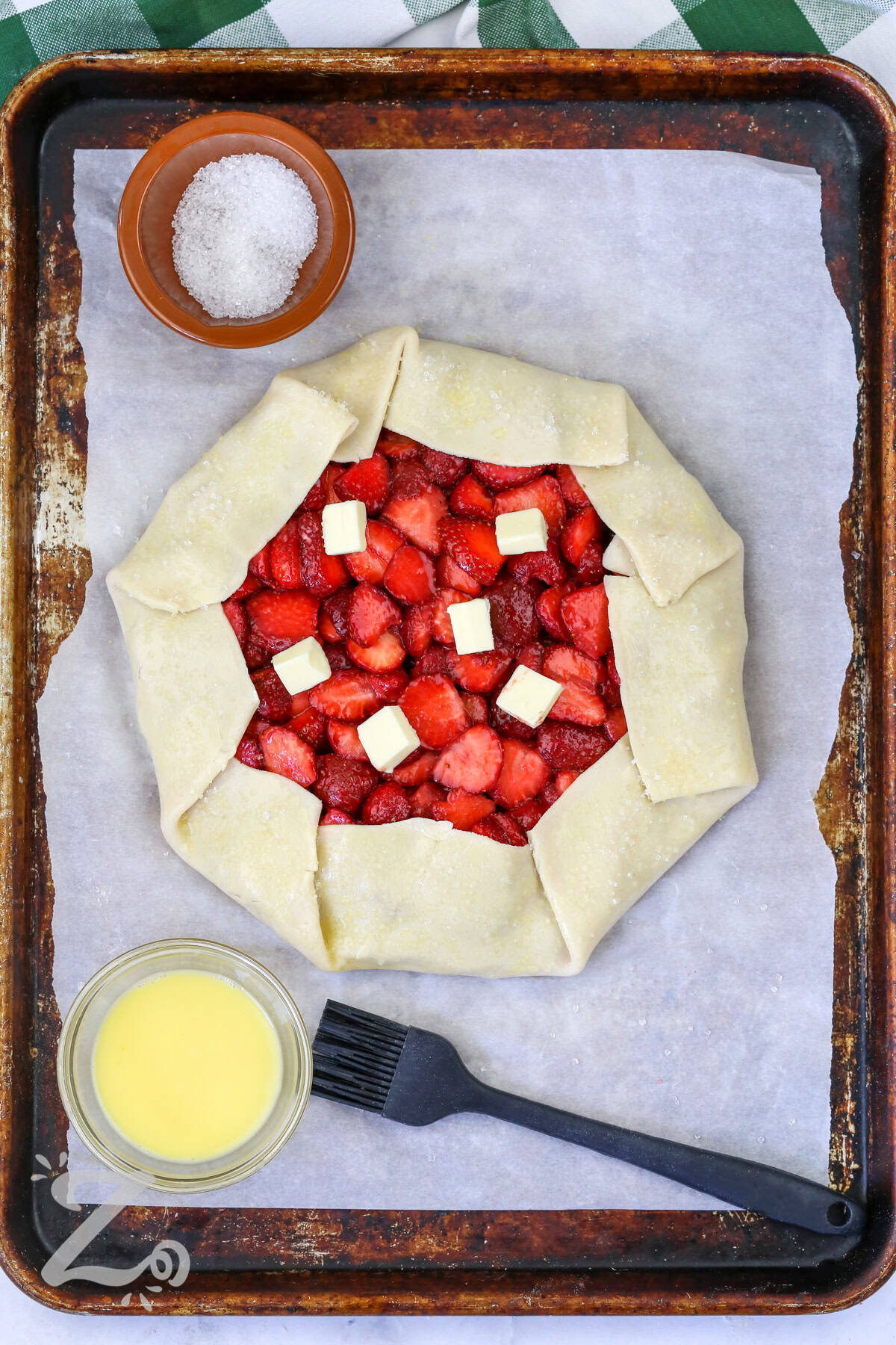 adding butter to Strawberry Galette