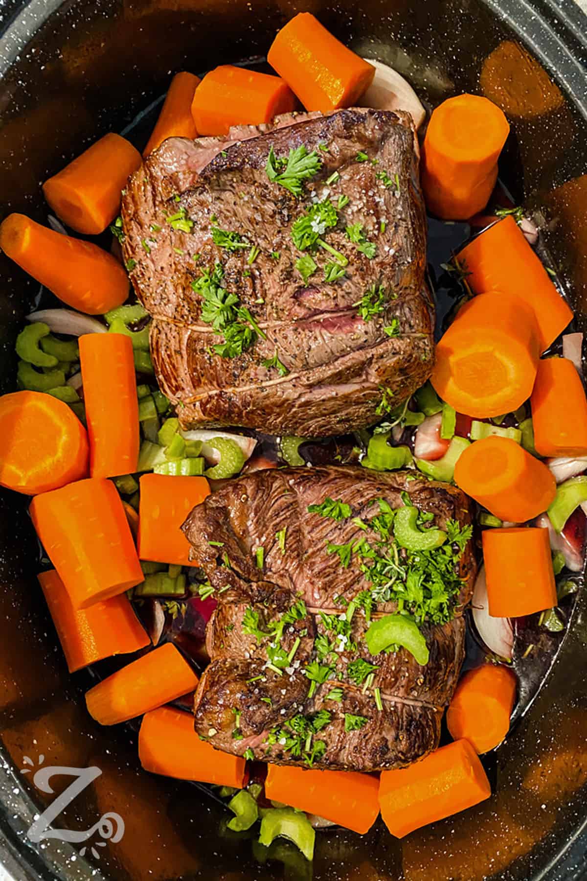 Best Pot Roast with carrots , celery and onion in the pot