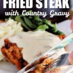 chicken fried steak with country gravy on a white plate, and a knife and fork cutting off a slice, with a title